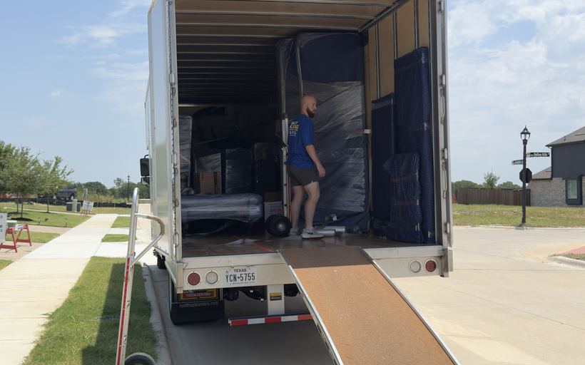A buddy moving a blanket-wrapped stack on a dolly