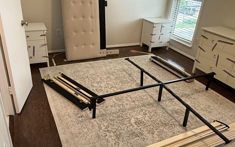 A buddy reassembling a bed frame