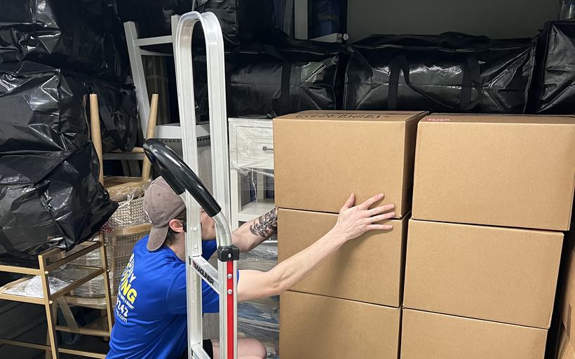 A buddy stacking flat-packed moving boxes